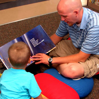Dad reading to child at the library